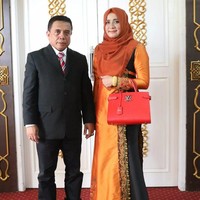 Darwati, istri Gubernur Aceh Irwandi Yusuf, bergaya penuh warna dengan busana muslim oranye-hitam dan tas Louis Vuitton seri Twist Tote berwarna merah seharga US$ 3.000 atau sekitar Rp 39 juta. (Foto: dok. Instagram)