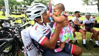 Seorang pebalap bermain dengan anaknya sebelum bertanding di Etape Pertama Yogyakarta-Ngawi.