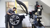 Mekanik memeriksa ban mobil BMW.