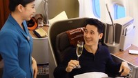 Saat sedang bepergian dengan pesawat terbang, Nino duduk di kelas bisnis dan menikmati sepiring makanan dengan air putih, kopi, jus jeruk di meja, sementara segelas white wine di genggamannya. Foto: Instagram @ninojkt