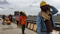 Para pekerja tengah membangun rel LRT.