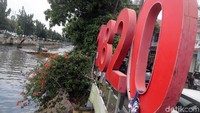 Pekerja dengan alat berat mengeruk endapan sampah bercampur lumpur.