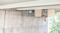 Dinding yang terbuat dari kayu bisa dilipat dan sisi lainnya berfungsi sebagai pintu. Sang desainer bisa duduk sembari kakinya menjuntai ke bawah. Boredpanda/Istimewa.