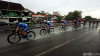 Para pebalap tetap memacu sepedanya meski hujan mengguyur jalur yang dilintasi.