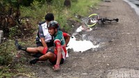 Seorang pebalap meringis kesakitan usai terjatuh.