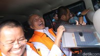 Antonius Tonny Budiono memasuki mobil tahanan KPK sambil melempar senyuman kepada awak media.