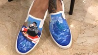 Dalam gambar tersebut, tampak kaki Susi begitu kontras dengan sepatu berlukis gambar dirinya yang tengah di atas kano sambil meminum kopi. Istimewa/Deelukis.