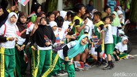 Sejak siang mereka sudah berdiri berjejer di pinggir jalan yang akan dilintasi oleh para pebalap.