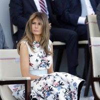 Dress putih bermotif floral dari label Italia Valentino membungkus tubuh Melania Trump saat menghadiri parade Bastille Day di Paris Juli 2017. Foto: Getty Images