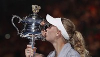 Tahun 2010 lalu Wozniacki mampu menjadi petenis putri peringkat satu dunia, tapi kegagalan menjuarai grand slam membuatnya saat itu terus dikritik. Penantian sudah usai, kini ia bisa memuaskan diri mencium trofi dambaan. (Foto: Issei Kato/REUTERS)