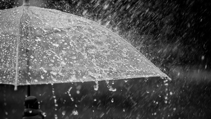 Splashing water on umbrella in the rain in black and white color tone