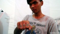 Seorang warga menunjukan tatonya yang hampir hilang.