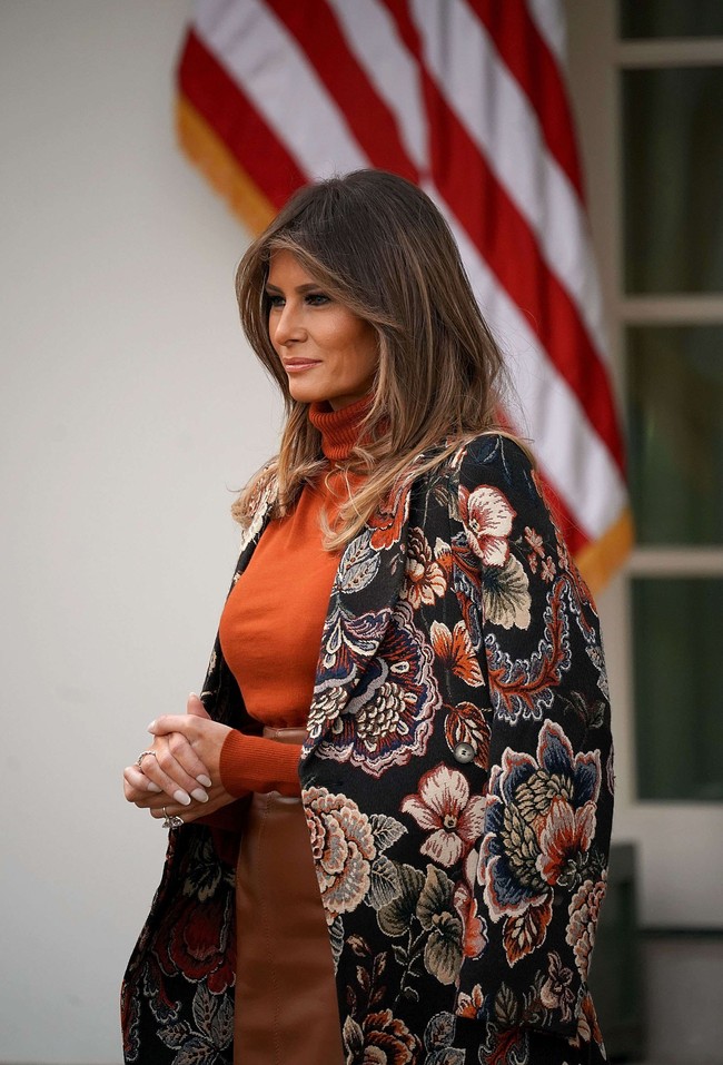 Coat bermotif floral karya desainer Inggris Stella McCartney melengkapi busana nuansa coklat Melania. Foto: Getty Images