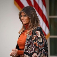 Coat bermotif floral karya desainer Inggris Stella McCartney melengkapi busana nuansa coklat Melania. Foto: Getty Images