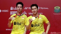 Kevin/Marcus menunjukkan medali yang diraihnya.