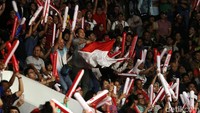 Pendukung Indonesia mengibarkan bendera merah putih.