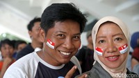 Mereka datang dengan beragam gaya, salah satunya menempeli pipinya dengan bendera.
