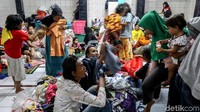 Warga mencoba baju layak pakai yang sempat diselamatkan.  
