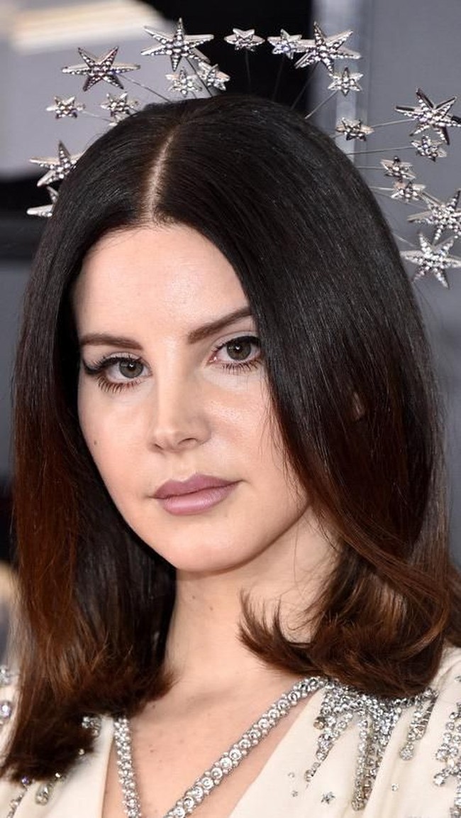 Lana Del Rey tampil memukau dengan aksesori bintang-bintang di kepalanya. Lipstik warna mauve dan winged eyeliner dramatisnya semakin membuat penampilannya ekstravaganza.  Foto: Getty Images