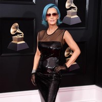 Jenny McCarthy mengenakan gaun berbahan PVC yang mengilap, kacamata hitam berikut wig biru. Sebuah perpaduan yang terkesan murahan. (Foto: Getty Images)