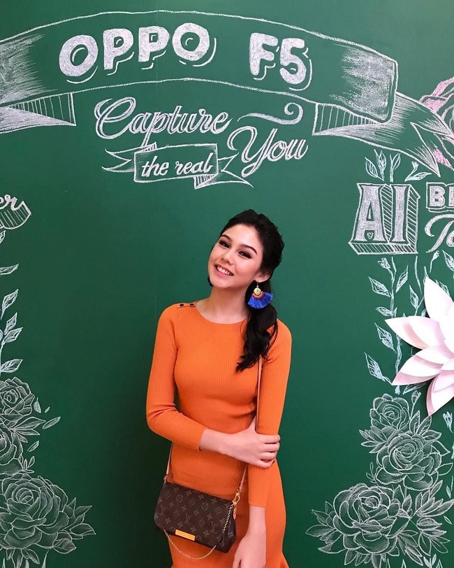 Vanesha pun pernah memilih dress oranye legan panjang. Tampilannya semakin feminin dengan statement earrings dan tas selempang Louis Vuitton. Foto: Instagram Vanesha Prescilla