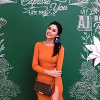 Vanesha pun pernah memilih dress oranye legan panjang. Tampilannya semakin feminin dengan statement earrings dan tas selempang Louis Vuitton. Foto: Instagram Vanesha Prescilla