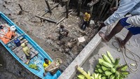 Warga melakukan aktivitas jual beli hasil bumi di Pelabuhan Agats, Kabupaten Asmat, Papua, Minggu (28/1). Masyarakat Asmat merupakan masyarakat pemburu-peramu yang sangat bergantung kepada alam.