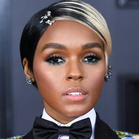 Janelle Monae tampil dengan rambut potongan pixie dengan warna sebelah platinum, setengah lagi hitam. Ia menambahkan aksesori di rambutnya yang membuat kesan lebih feminin. Makeup matanya dibuat dramatis dengan eyeshadow hijau di bawah matanya.  Foto: Getty Images