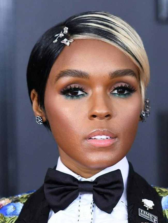 Janelle Monae tampil dengan rambut potongan pixie dengan warna sebelah platinum, setengah lagi hitam. Ia menambahkan aksesori di rambutnya yang membuat kesan lebih feminin. Makeup matanya dibuat dramatis dengan eyeshadow hijau di bawah matanya.  Foto: Getty Images