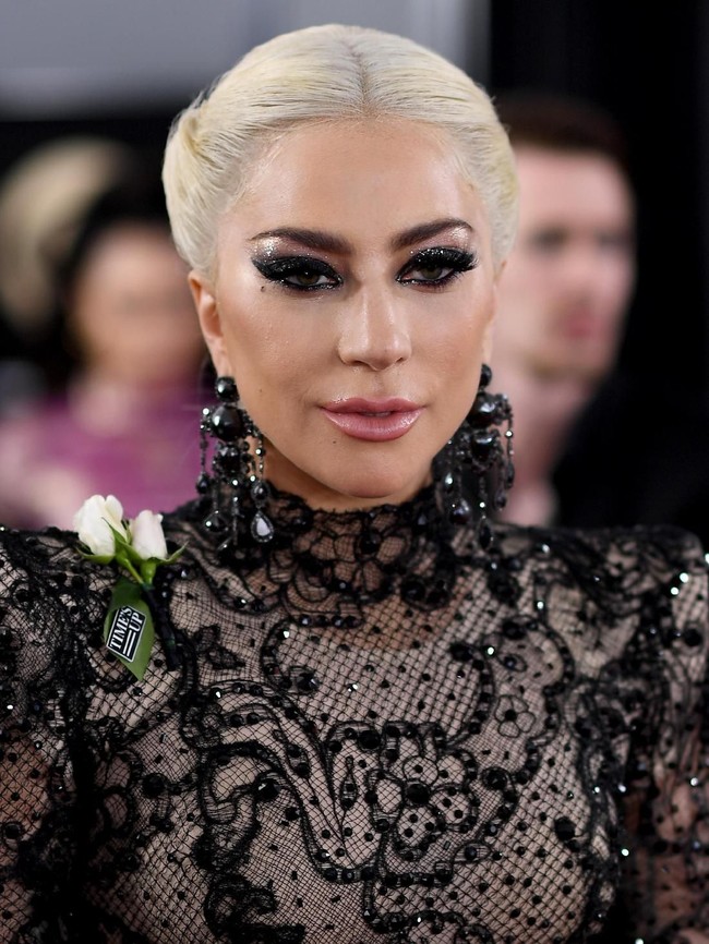 Sementara tampilan makeupnya dibuat tak kalah dramatis. Pelantun Bad Romance itu menonjolkan makeup-nya di area mata dengan tampilan smokey eyes bertabur glitter.  Foto: dok. Getty Images