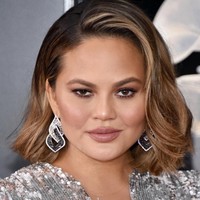 Mengikuti tren rambut 2018, Chrissy Teigen tampil dengan rambut lob (long bob). Sementara makeupnya bernuansa bronzy yang memberikan efek glowy skin.  Foto: Getty Images