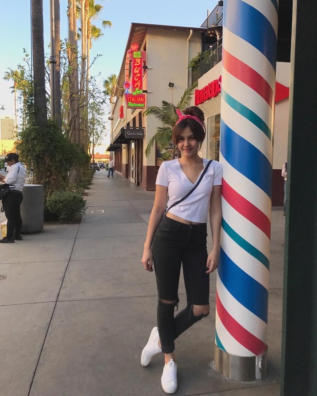 Penampilan t-shirt putih dan celana jeans hitam bisa menjadi manis dengan tambahan aksesori feminin seperti bandana. Foto: Instagram Vanesha Prescilla