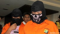 Para tersangka dihadirkan dengan memakai baju tahanan dan penutup kepala.