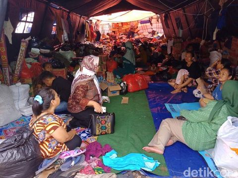 Tampak kondisi di dalam tenda penuh oleh pengungsi beserta barang kiriman bantuan berupa pakaian bekas dan logistik