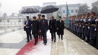 Presiden Ashraf Ghani menyambut kedatangan Presiden Jokowi di tengah guyuran hujan salju. Reuters/Massoud Hossaini.