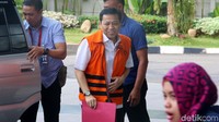 Novanto tampak tiba di KPK dengan diantar mobil tahanan. Ia tampak menenteng map merah.