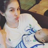 Berfoto bersama kedua orangtuanya, Raphael Moeis terlihat memakai bibs atau celemek bayi dari brand Marc Jacobs. Bibs ini dijual bersamaan dengan romper yang merupakan bagian dari gift set.  Harganya berkisar US$ 100 atau sekitar Rp 1,3 juta. Foto: Instagram