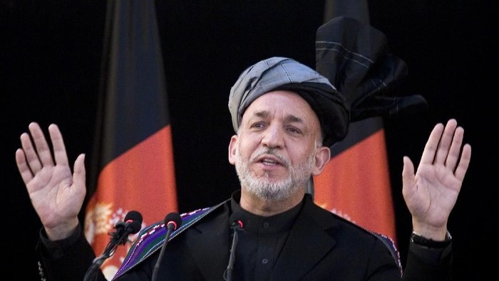 KUNDUZ, AFGHANISTAN - APRIL 11:  Kunduz Governor Mohammed Omar helps Afghan President Hamid Karzai put on a turban during a meeting with elders on April 11, 2010  in Kunduz, Afghanistan.  President Karzai urged Taliban insurgents on Sunday to lay down their arms and air their grievances while visiting a violent northern province, adding that foreign forces would not leave the country as long as fighting continued. (Photo by Dusan Vranic-pool/Getty Images)