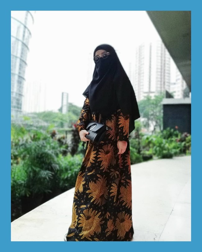 Seperti saat pergi ke kondangan, Wafiq Malik tetap memakai busana resmi seperti dress batik. Ia mengombinasikan dress batik berwarna keemasan dengan hijab cadar berwarna hitam. Foto: Instagram/WafiqMalik