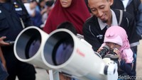 Seorang anak meneropong bulan.