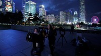 Warga di Hongkong bersiap untuk menyaksikan gerhana bulan. Foto: REUTERS/Bobby Yip