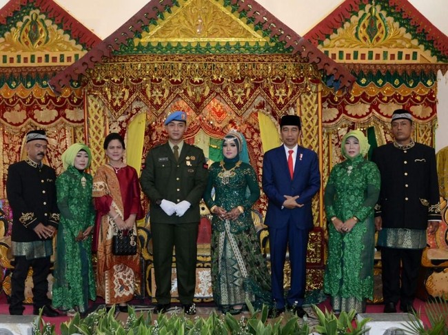 Presiden Joko Widodo (Jokowi) dan Ibu Negara Iriana menghadiri resepsi pernikahan anggota Grup A Paspampres, Pratu Dora Wisnu Agung dengan Dara Deswantari pada awal Januari 2018. Saat itu Iriana terlihat memadukan tunik dan kain batik motif buketan dengan tas Lady Dior. Foto: Biro Pers Setpres