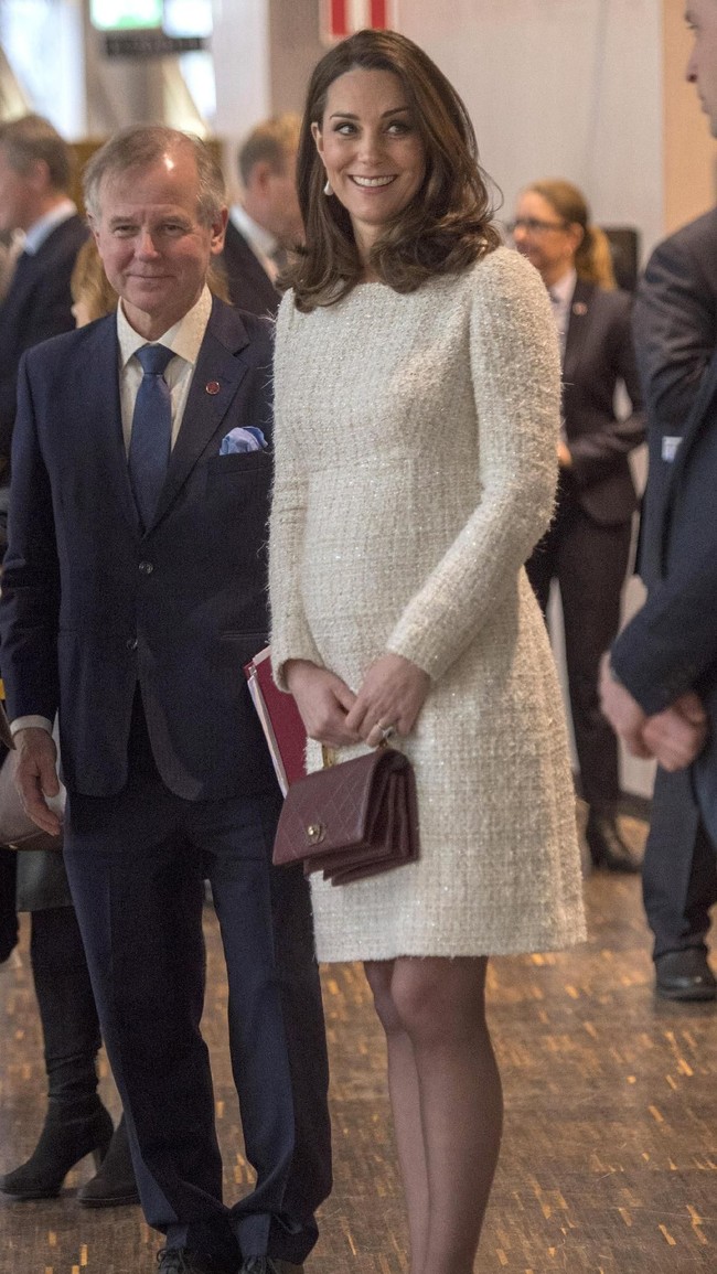 Mantel houndstooth itu membungkus mini-dress putih Alexander McQueen. (Foto: Getty Images)