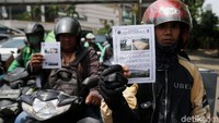 Pengendara menunjukkan pamflet sosialisasi jalur khusus sepeda motor.