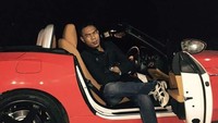 Sementara itu di mobil Ferrari bercat mewah yang diunggah, Aom berpose duduk di kursi depan dengan pintu depan mobil terbuka.