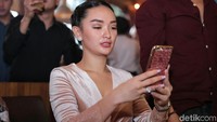 Ia pun tampak asik dengan handphonenya. Pool/Ismail/detikFoto.