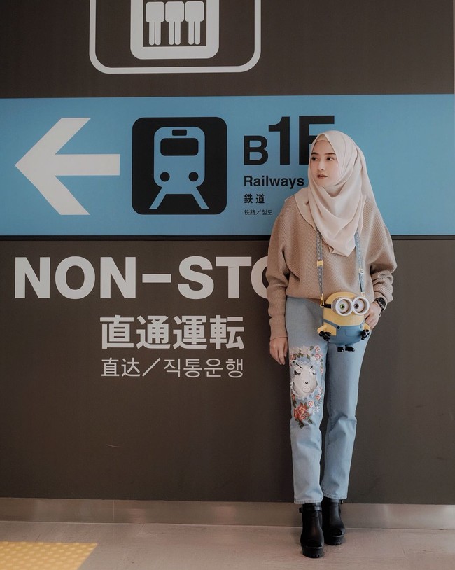 Gaya hijab yang tak kalah menarik untuk berlibur di Jepang adalah gaya Nisa Cookie. Menerapkan fesyen ala Jepang, Nisa Cookie tampil playful dengan tas minion dan celana jeans. Foto: Instagram