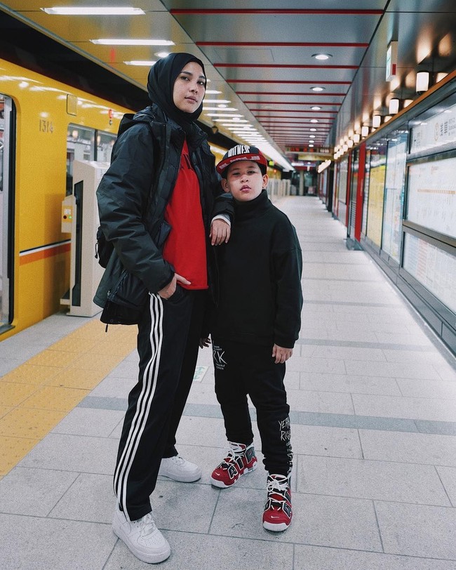 Berlibur bersama anaknya, Rani Hatta bergaya simple. Ia hanya memakai jaket, T-Shirt, dan celana training. Gayanya yang praktis jadi ide bagus untuk para ibu yang membawa anak saat berlibur agar bisa bebas bergerak. Foto: Instagram