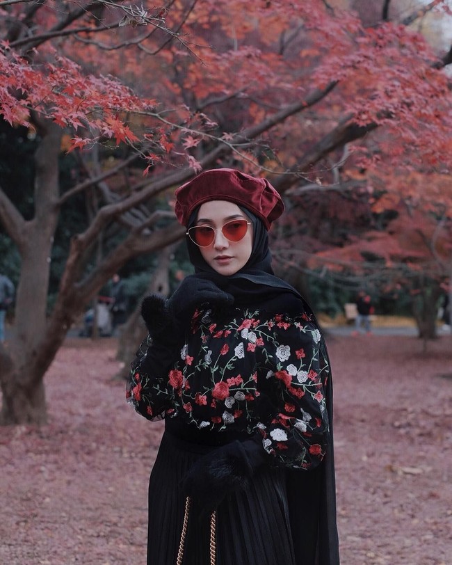 Menikmati dedaunan yang jatuh di musim gugur, Nisa Cookie tampil matching dengan busana motif floral berwarna hitam dan merah. Ia pun memakai topi baret dan kaca mata berwarna senada. Foto: Instagram