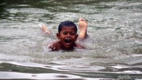 Seorang anak berenang di Kali Sipon, Tangerang Banten.